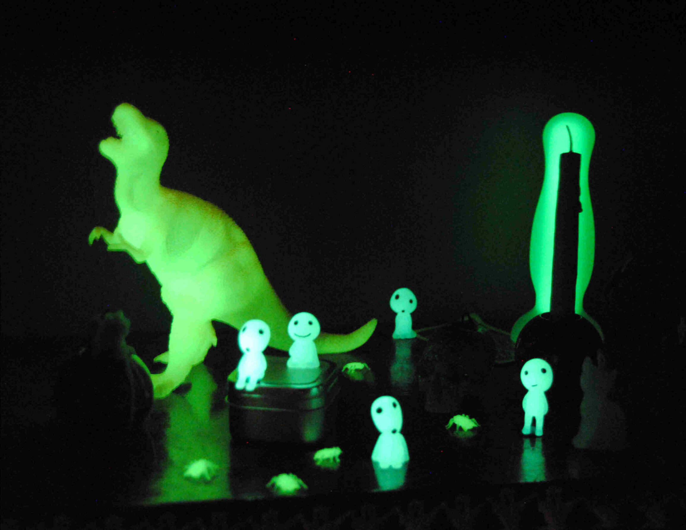 picture of a glow-in-the-dark toy dinosaur and other glow-in-the-dark-objects, in the dark